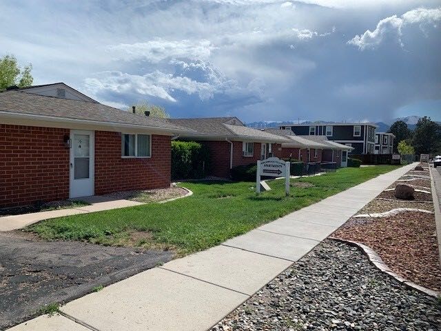 Single-level brick ranch apartment homes along a sidewalk