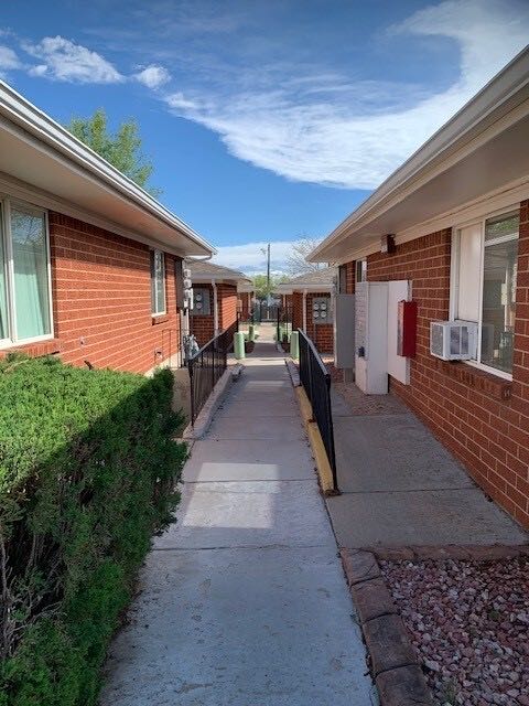 Landscaped walkway between brick apartment buildings